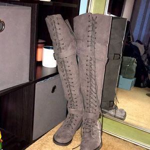 Knee high, laced up grey boots.